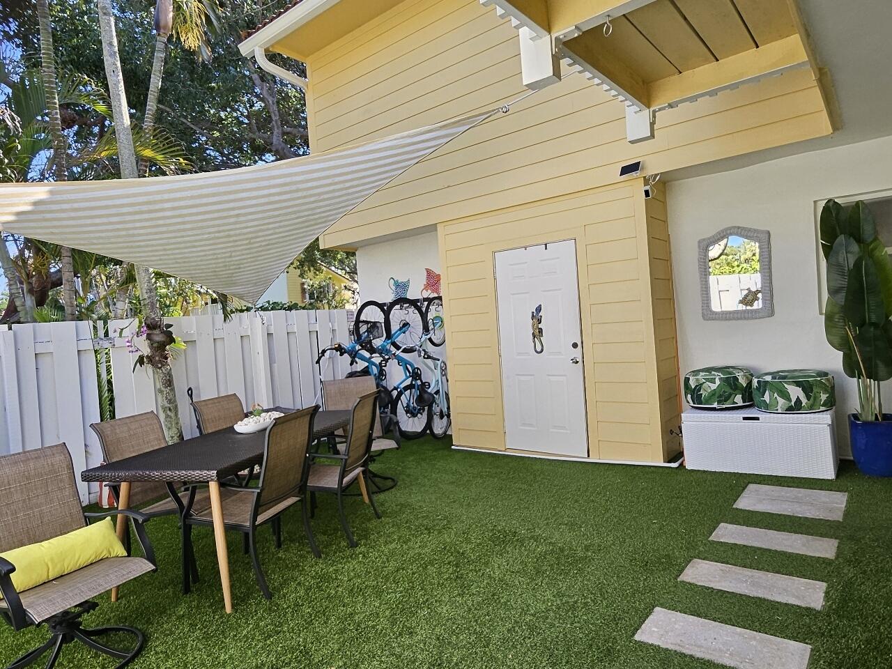 226 Seabreeze Circle Jupiter, FL 33477 - Photo 13 of 22 a view of a backyard with table and chairs and potted plants