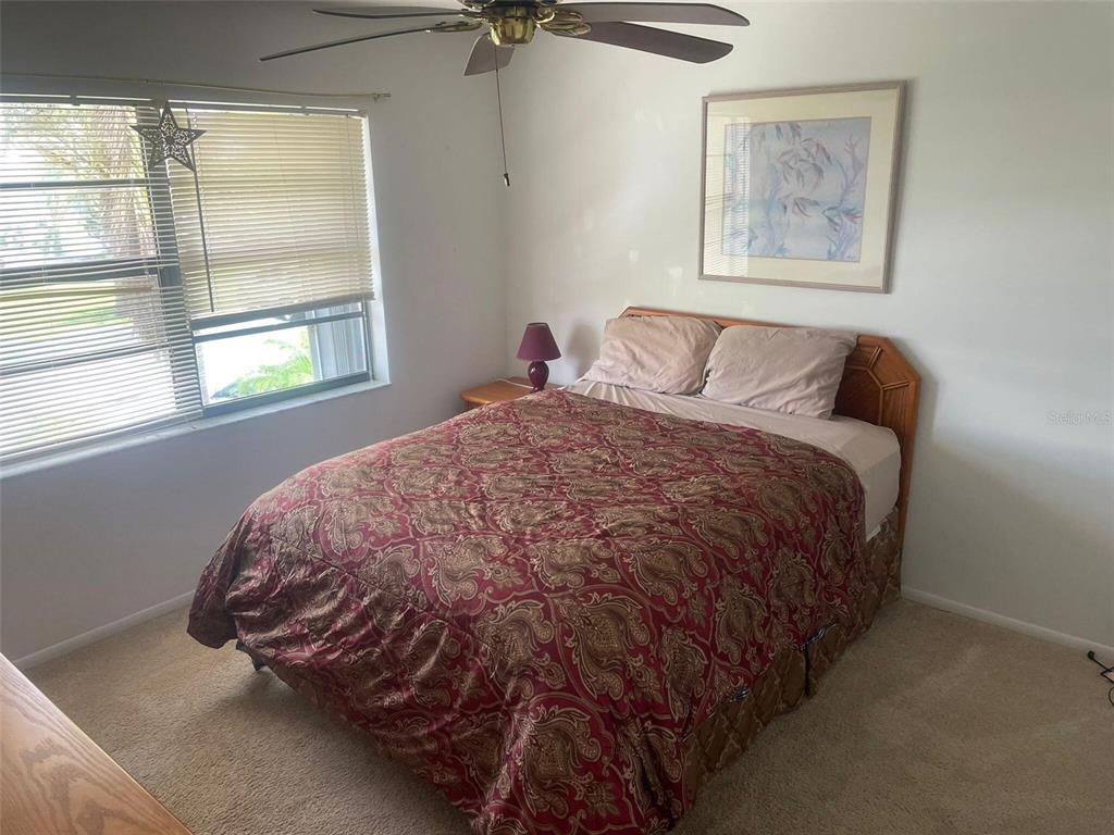 26485 Rampart Boulevard, Unit A27 Punta Gorda, FL 33983 - Photo 12 of 19 a bed sitting in a bedroom next to a window