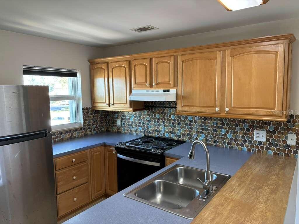 26485 Rampart Boulevard, Unit A27 Punta Gorda, FL 33983 - Photo 6 of 19 a kitchen with a sink stove and refrigerator