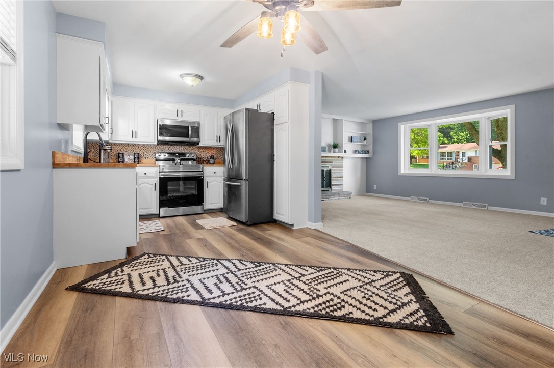 4895 3rd Street Northwest Canton, OH 44708 - Photo 27 of 27 Kitchen with appliances with stainless steel finishes, a ceiling fan, white cabinetry, open floor plan, and wood finished floors