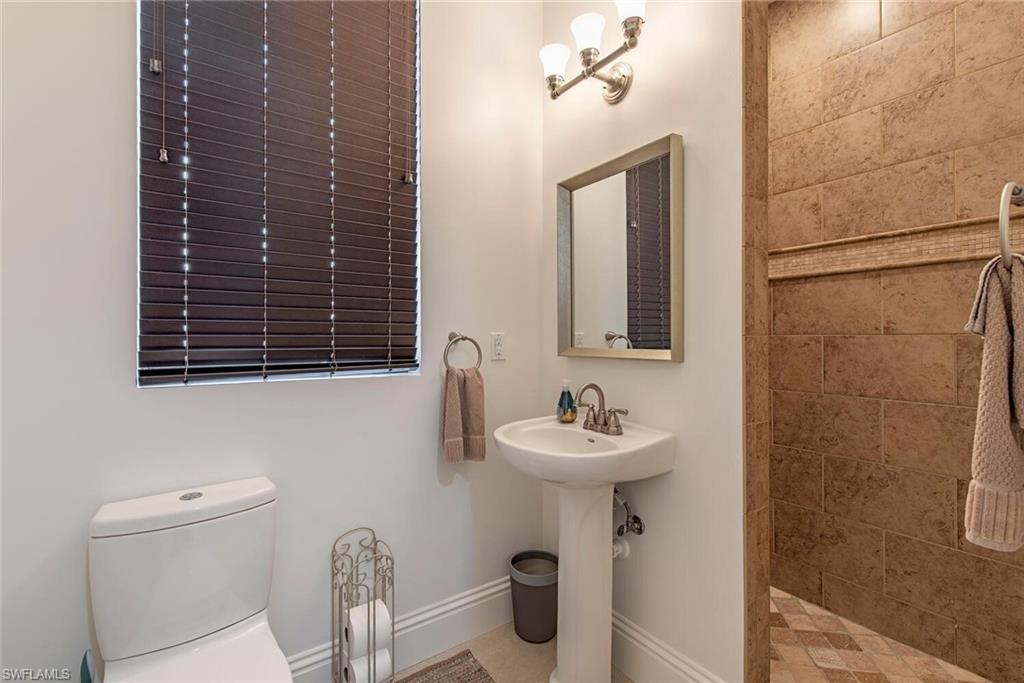 1012 7th Street South, Unit B2 Naples, FL 34102 - Photo 14 of 17 a bathroom with a sink a toilet and mirror