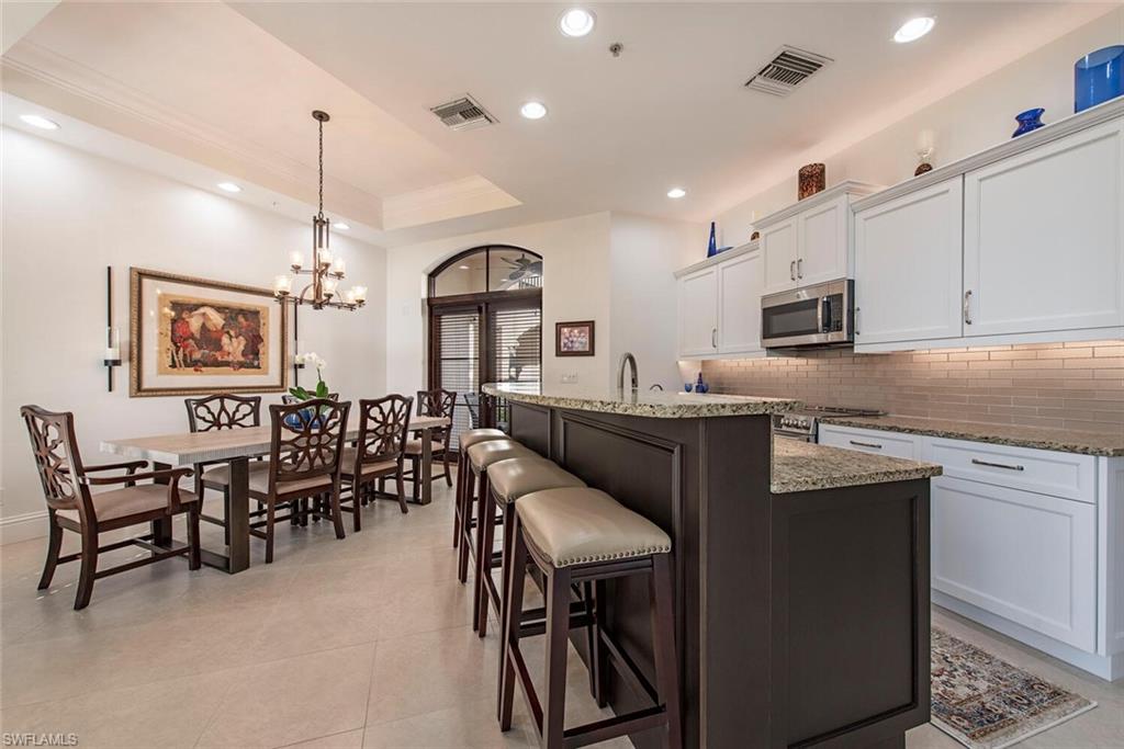 1012 7th Street South, Unit B2 Naples, FL 34102 - Photo 6 of 17 a kitchen with cabinets a sink stainless steel appliances and dining table