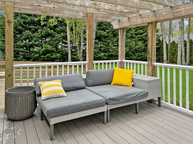a balcony with wooden floor and outdoor seating