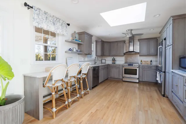 a kitchen with cabinets wooden floor and stainless steel appliances