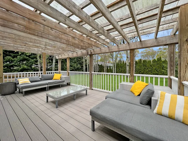 a outdoor space with the couches and dining table with the garden view