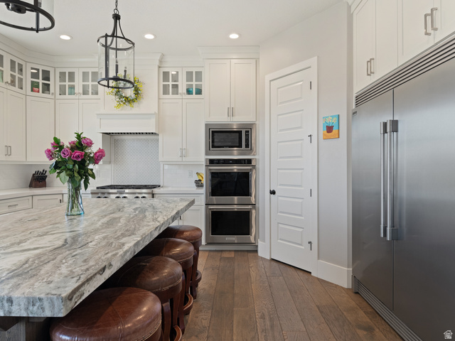 641 West 500 South Midway, UT 84049 - Photo 15 of 52 Spacious kitchen featuring a large island with a substantial stone countertop, wood-finish flooring, white cabinetry, stainless steel appliances, and a built-in double oven