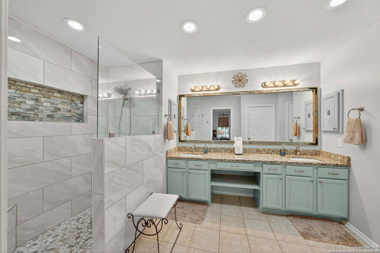231 Hayden Road Pleasanton, TX 78064 - Photo 21 of 36 a spacious bathroom with a granite countertop sink a mirror and shower