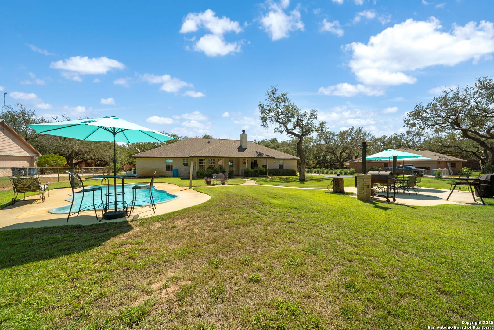 231 Hayden Road Pleasanton, TX 78064 - Photo 29 of 36 a view of a swimming pool with lawn chairs under an umbrella