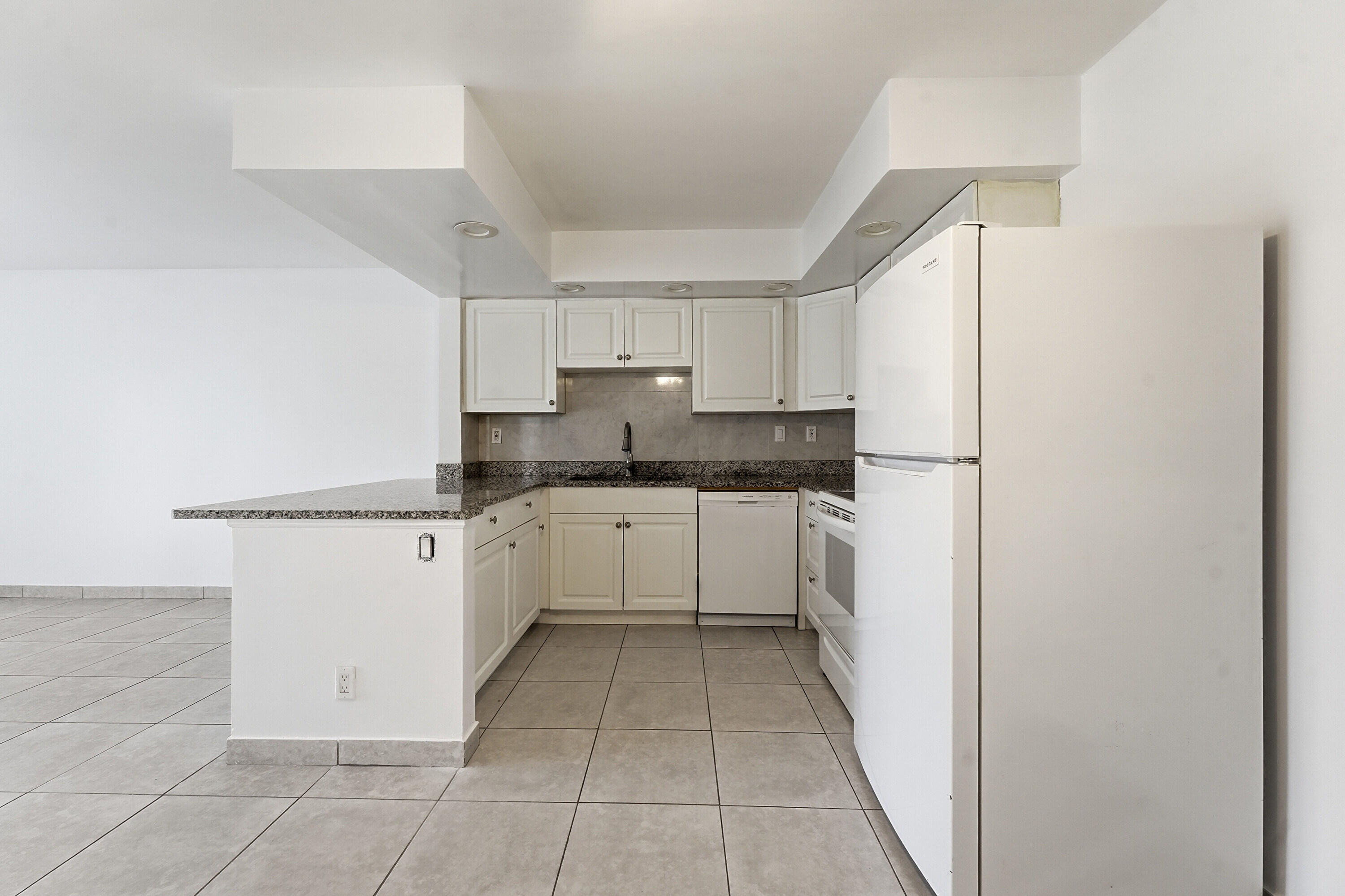 2671 Riverside Drive, Unit 1 Coral Springs, FL 33065 - Photo 8 of 25 a kitchen with white cabinets and white appliances