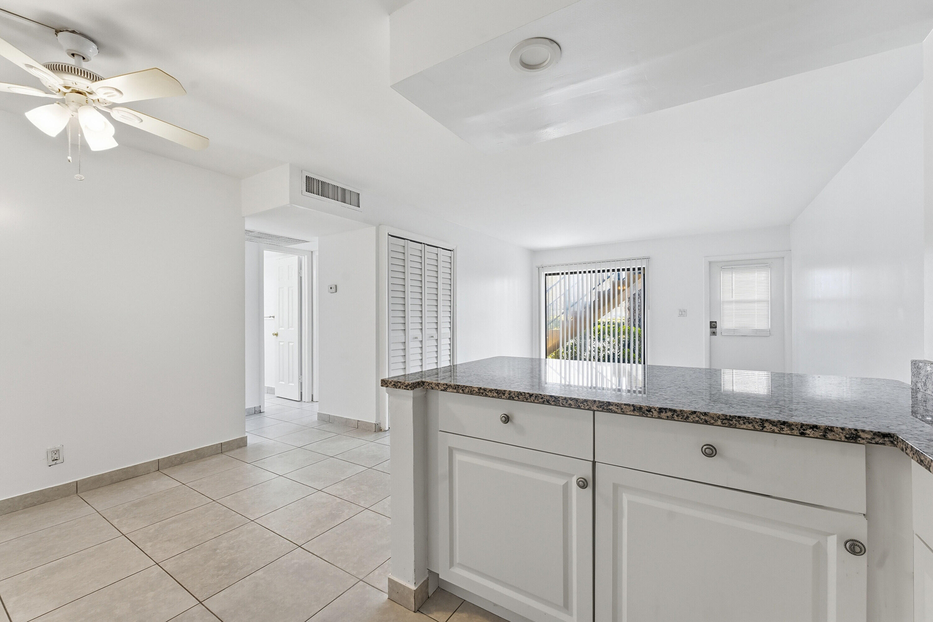 2671 Riverside Drive, Unit 1 Coral Springs, FL 33065 - Photo 10 of 25 a bathroom with a granite countertop sink two mirror and a vanity