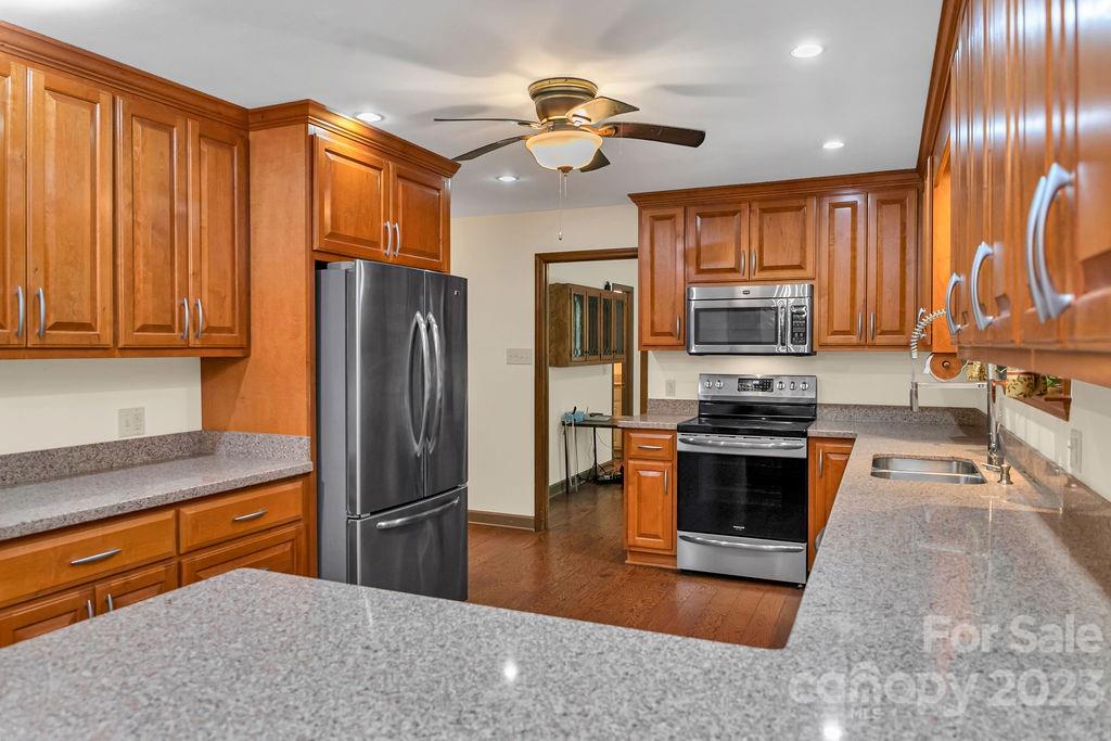 330 Beau Valley Road Tryon, NC 28782 - Photo 14 of 42 a kitchen with stainless steel appliances granite countertop a refrigerator a stove top oven a sink and dishwasher