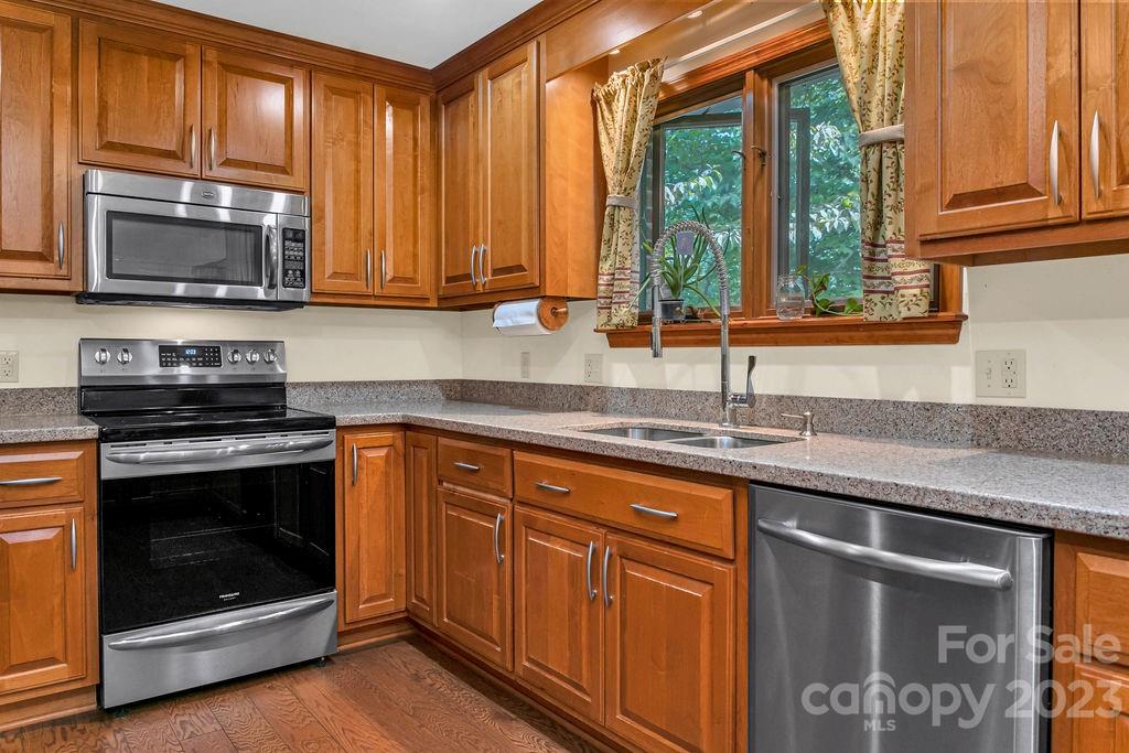 330 Beau Valley Road Tryon, NC 28782 - Photo 15 of 42 a kitchen with stainless steel appliances granite countertop a stove a sink and a microwave