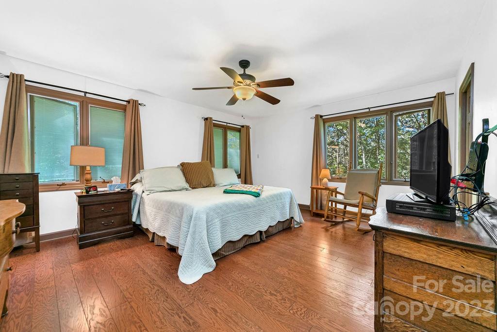 330 Beau Valley Road Tryon, NC 28782 - Photo 20 of 42 a spacious bedroom with a large bed and a chandelier
