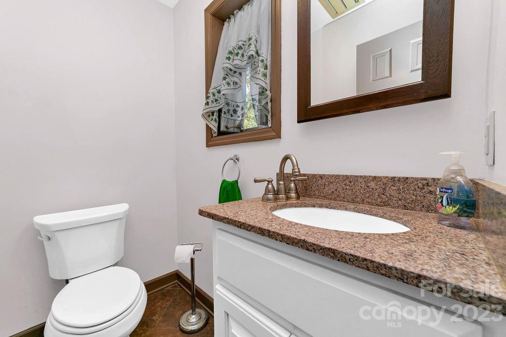 330 Beau Valley Road Tryon, NC 28782 - Photo 29 of 42 a bathroom with a granite countertop toilet sink and mirror