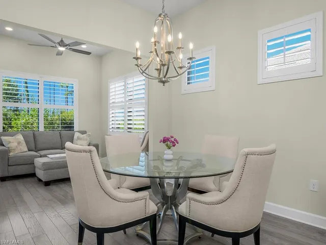 a living room with dining table and a chandelier