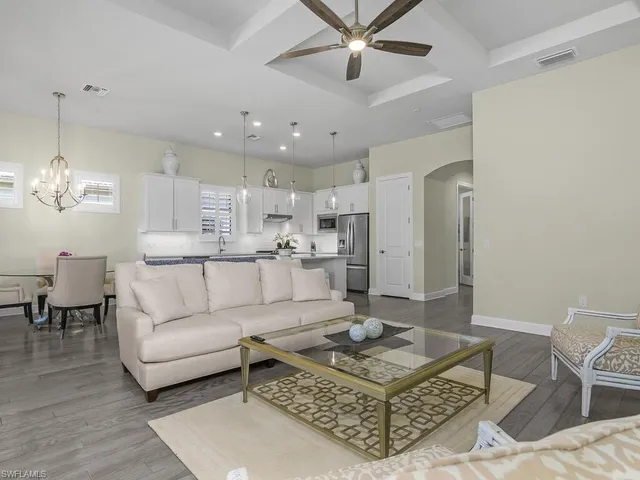 a dining room with furniture a chandelier and wooden floor
