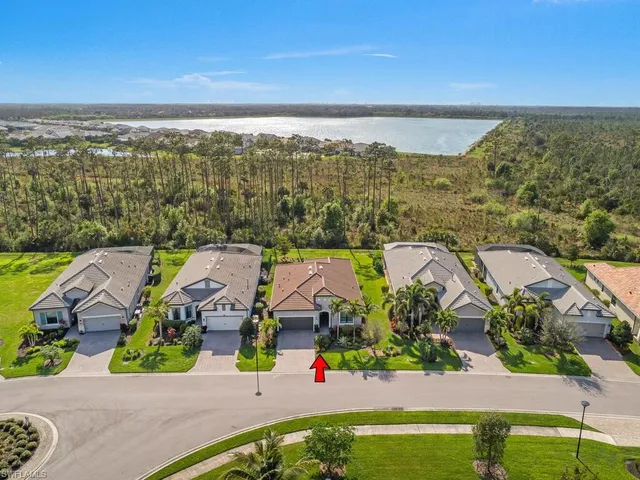 an aerial view of residential houses with outdoor space and ocean view