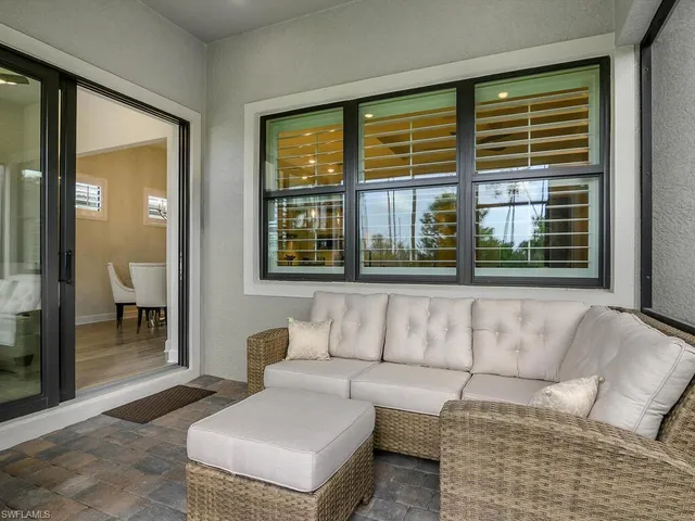 a living room with furniture and a floor to ceiling window
