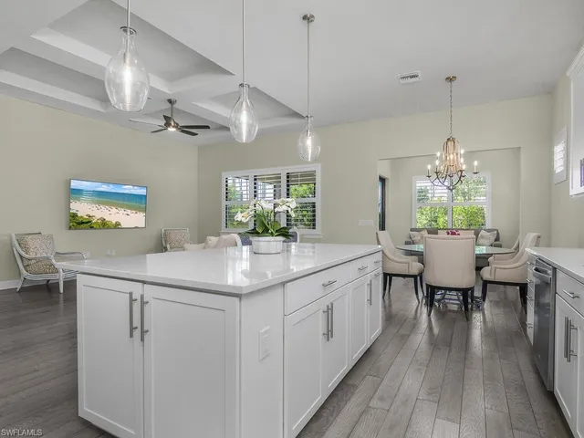 a kitchen with cabinets stainless steel appliances a sink and wooden floor