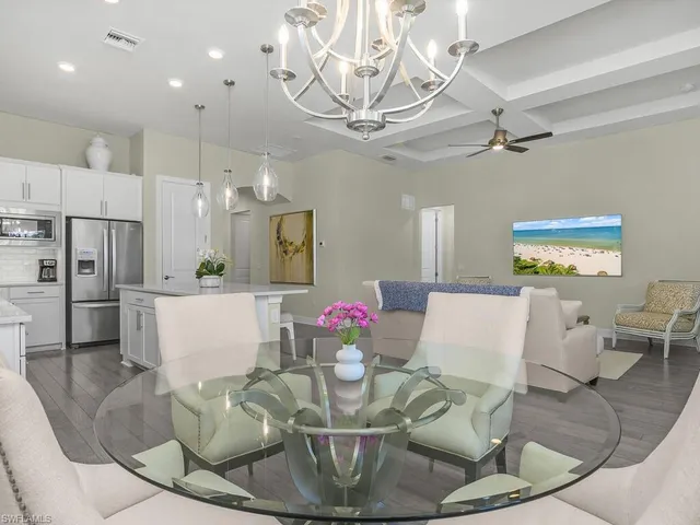 a kitchen with kitchen island a dining table chairs sink and wooden floor