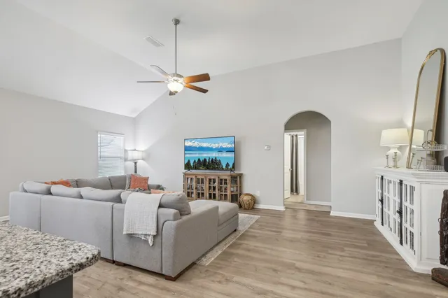a living room with furniture and a wooden floor