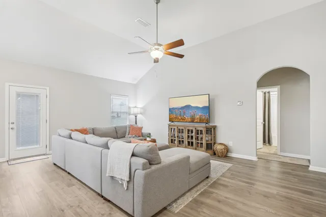 a living room with furniture and a wooden floor