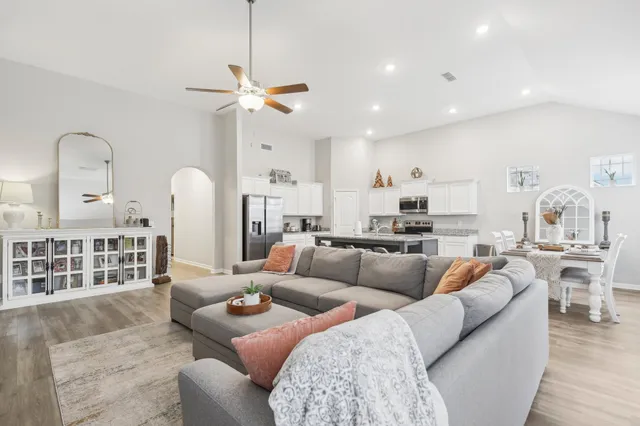 a living room with furniture a rug and kitchen view