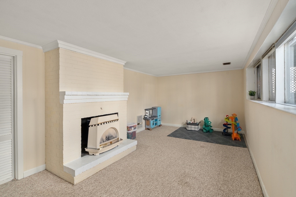 13 Berkeley Road Framingham, MA 01701 - Photo 21 of 32 a living room with furniture and a fireplace