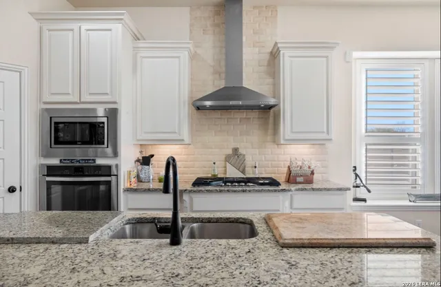 a kitchen with stainless steel appliances granite countertop a sink a stove and a granite counter tops