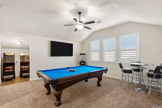 a living room with furniture pool table and flat screen tv