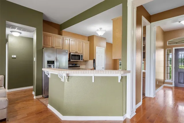 a kitchen with stainless steel appliances granite countertop a refrigerator a sink and a stove