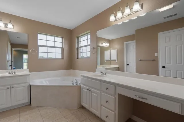 a spacious bathroom with a sink a large mirror and a shower