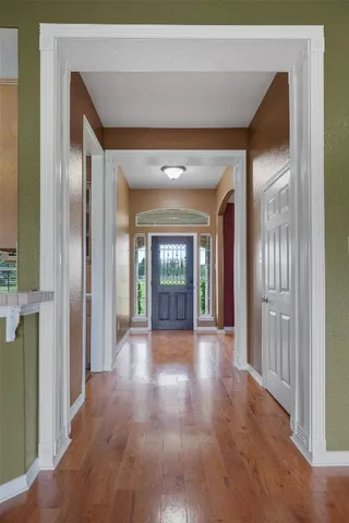 a view of a hallway with wooden floor and a living room