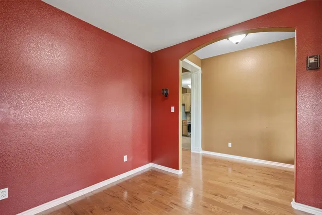 an empty room with wooden floor and entrance