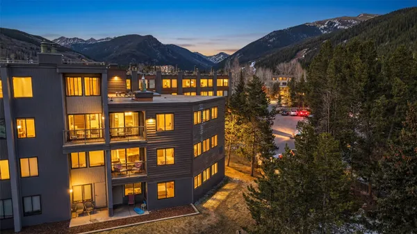 a view of building with a big yard and potted plants
