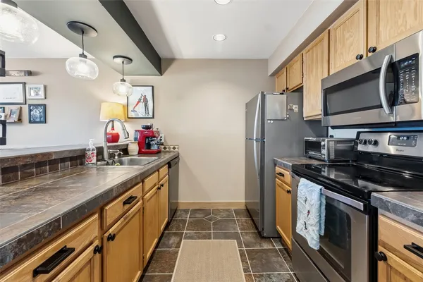 a kitchen with stainless steel appliances granite countertop a stove a sink and a microwave