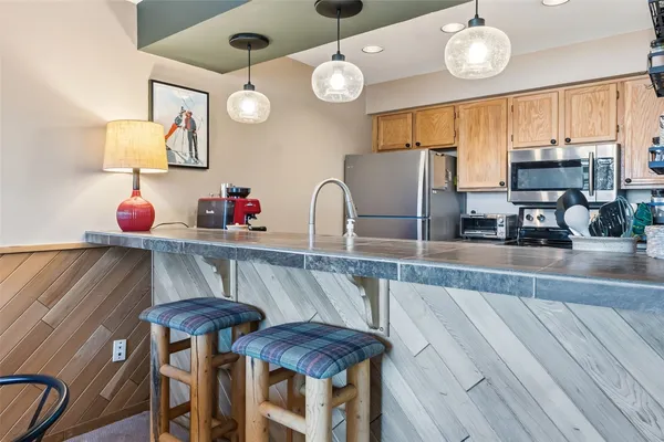 a kitchen with stainless steel appliances a table and chairs in it