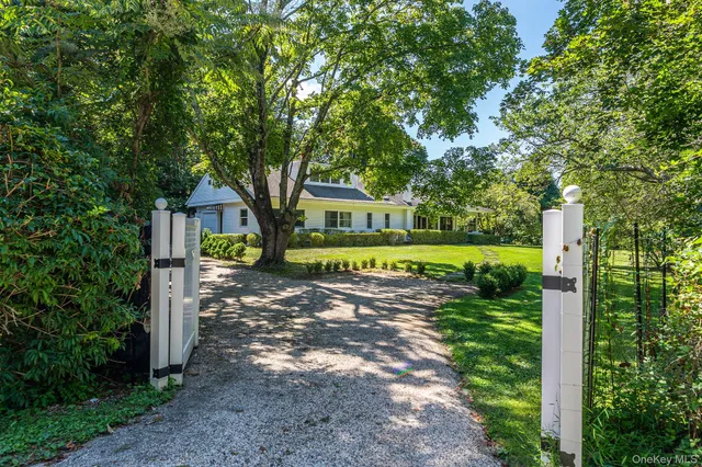 a view of a house with a big yard and large trees