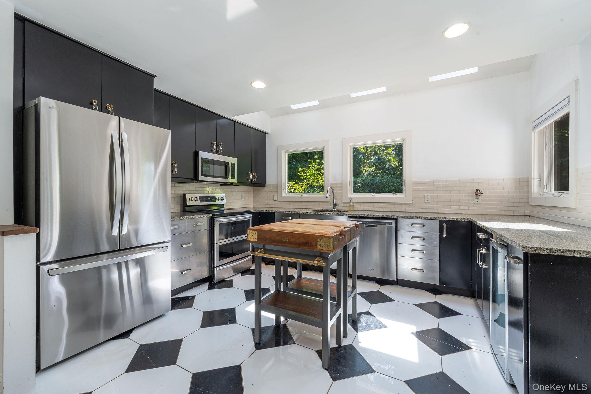 1 Gazon Road Shelter Island, NY 11964 - Photo 11 of 35 a kitchen with stainless steel appliances granite countertop a refrigerator a stove a sink a dining table and chairs