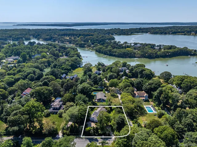 an aerial view of residential houses with outdoor space and lake view