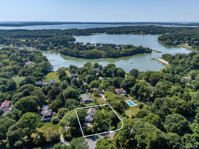 an aerial view of residential houses with outdoor space and lake view