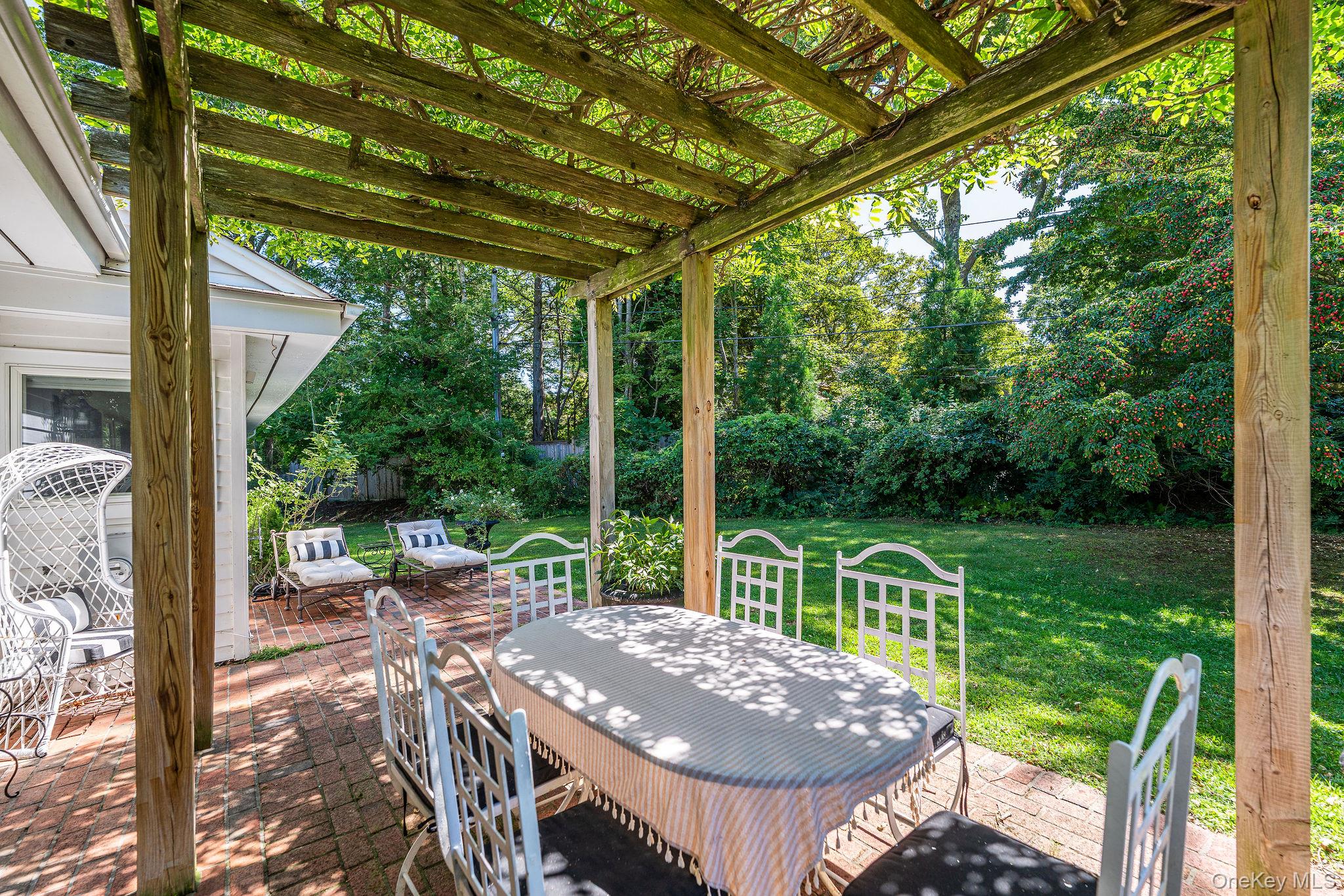 1 Gazon Road Shelter Island, NY 11964 - Photo 4 of 35 a view of a patio with a table chairs and a backyard