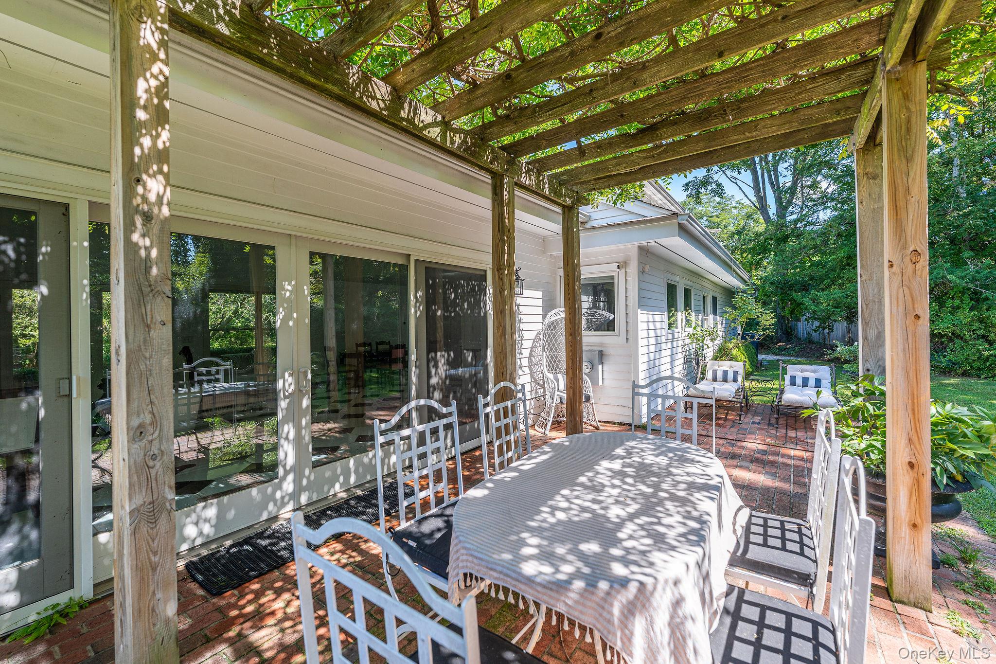 1 Gazon Road Shelter Island, NY 11964 - Photo 5 of 35 a view of a patio with table and chairs next to a yard