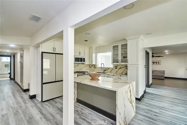 a kitchen with a refrigerator sink and cabinets