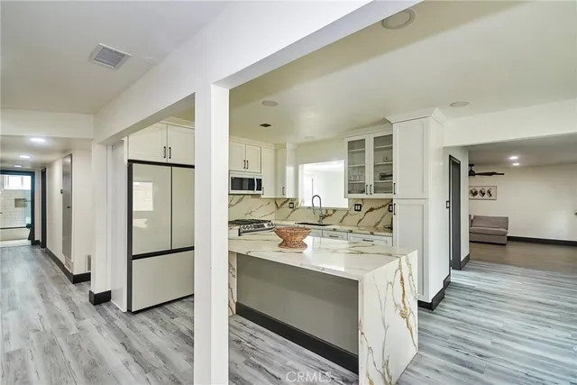 a kitchen with a refrigerator sink and cabinets