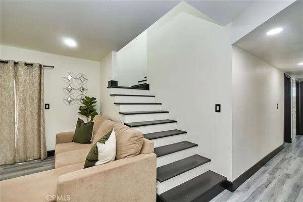 a view of a hallway with furniture and wooden floor