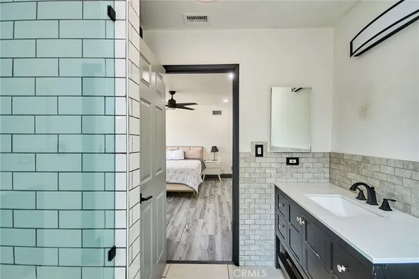 a bathroom with a sink and mirror with shower