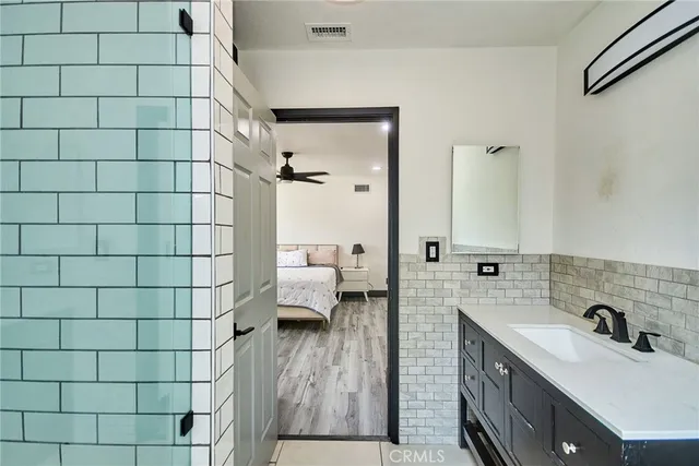 a bathroom with a sink and mirror with shower