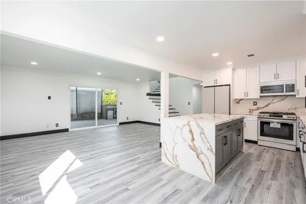 a large kitchen with stainless steel appliances granite countertop a large center island and a stove top oven