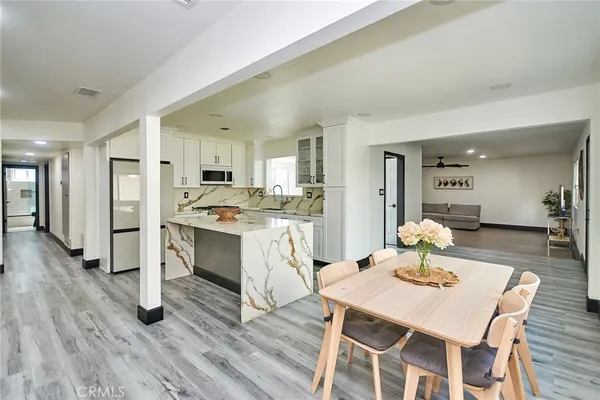 a living room with stainless steel appliances kitchen island granite countertop furniture and wooden floor